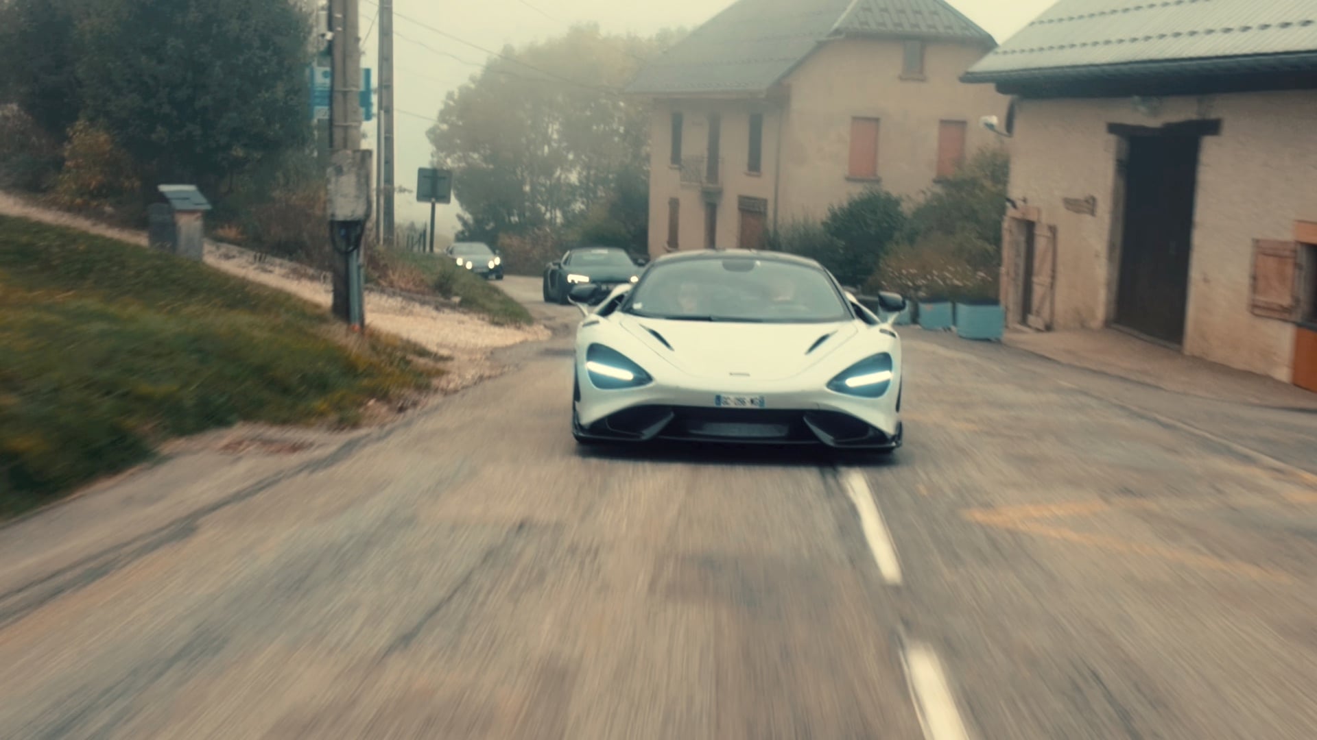 McLaren blanche sur une route de village lors de la First Édition